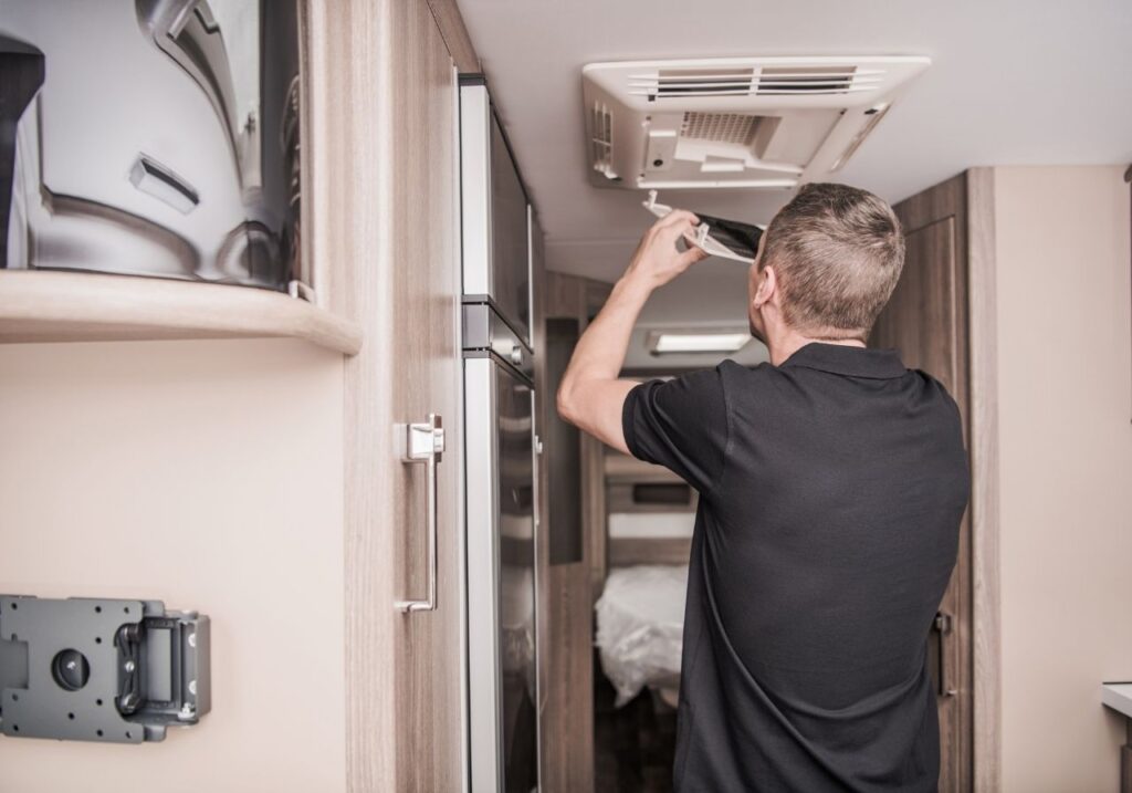 RV technician fixing an rv AC