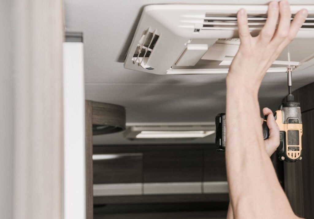 RV technician fixing an rv AC